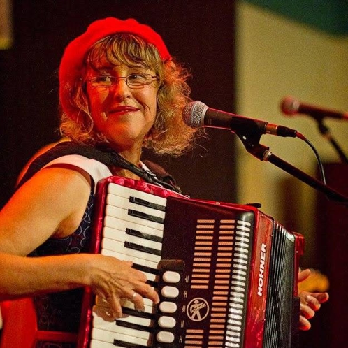 Juanita playing accordion Juanita wearing a red beret, plays her accordion at a performance